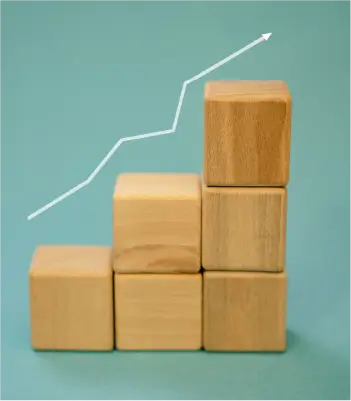 une pile de dés en bois qui grandissent, symbolisant la croissance de ton entreprise dans le temps avec une identité visuelle professionnelle.